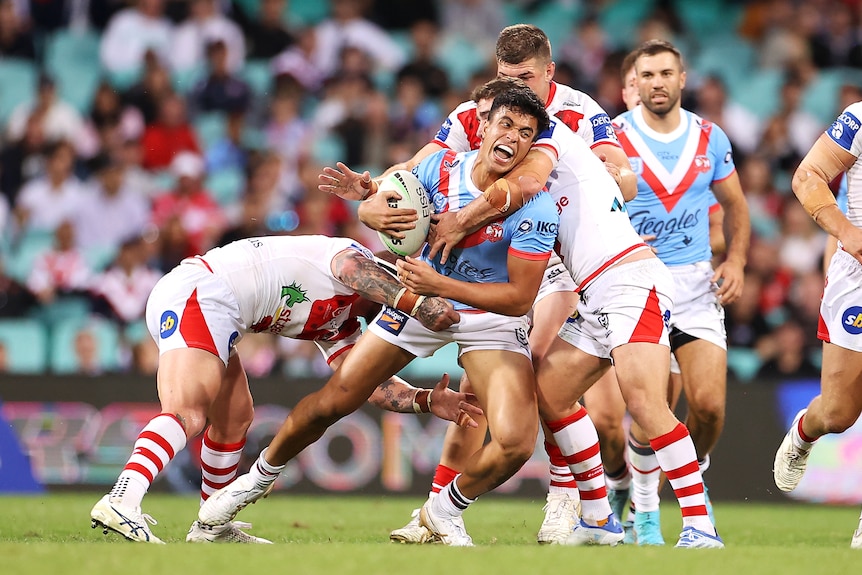 A man runs the ball during a rugby league match