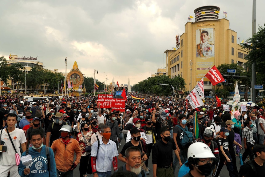 Street filled with thousands of people waving flags.