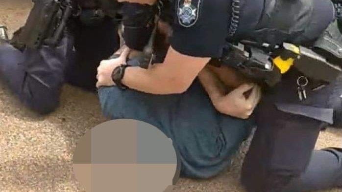 Police officers tackle a man to the ground