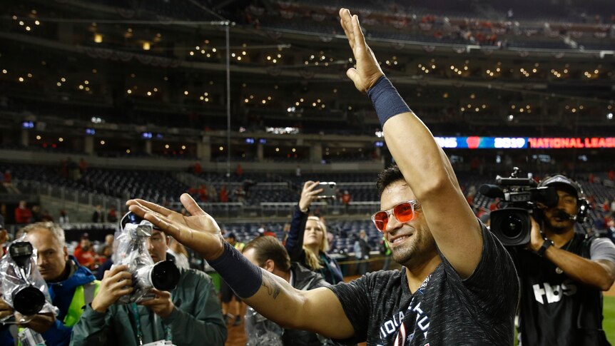 Gerardo Parra holds his hands out straight in an exaggerated clap with a smile on his face