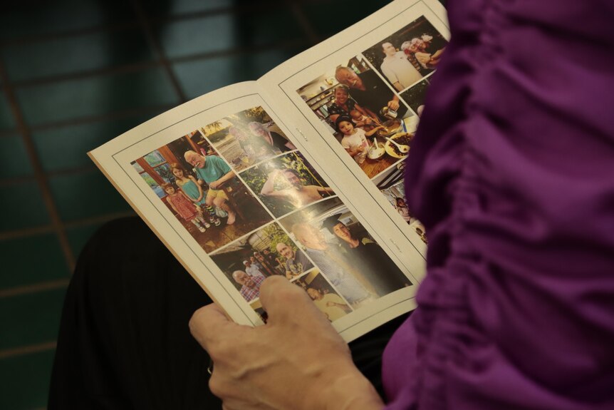Person reads a funeral booklet with pictures on both pages 