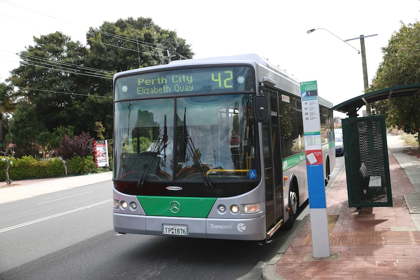 A Transperth bus on Guilford Road in Mt Lawley with a bus stop beside it.
