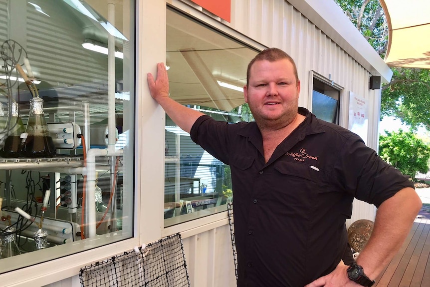 Man leans against wall of hatchery building