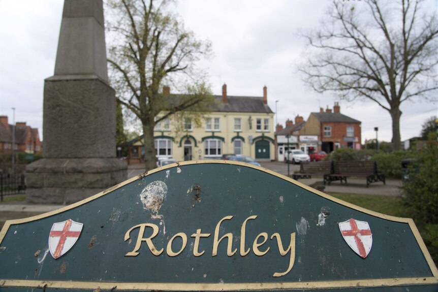 A sign displaying the word Rothley near a war memorial.