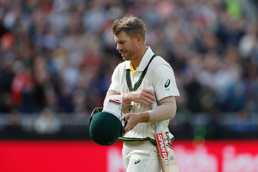 David Warner looks to the ground as he walks off following a dismissal