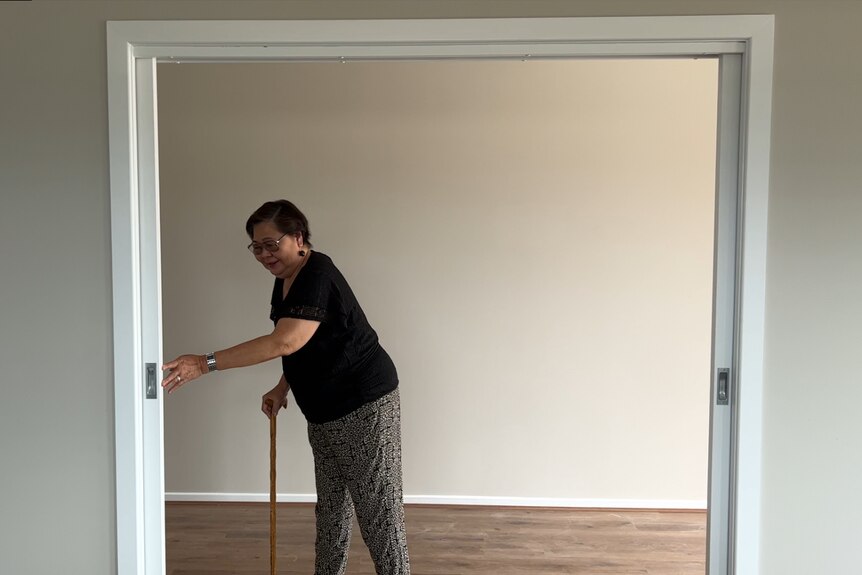 Phillipino woman sliding large doors to a hallway showing how accessible they are.