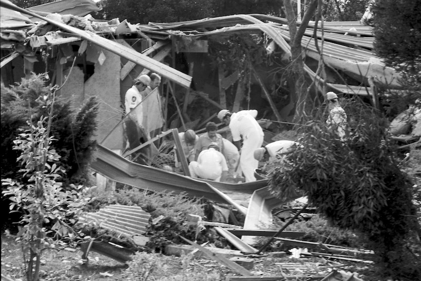 Police look through the bombed remains of Justice Richard Gee's house.