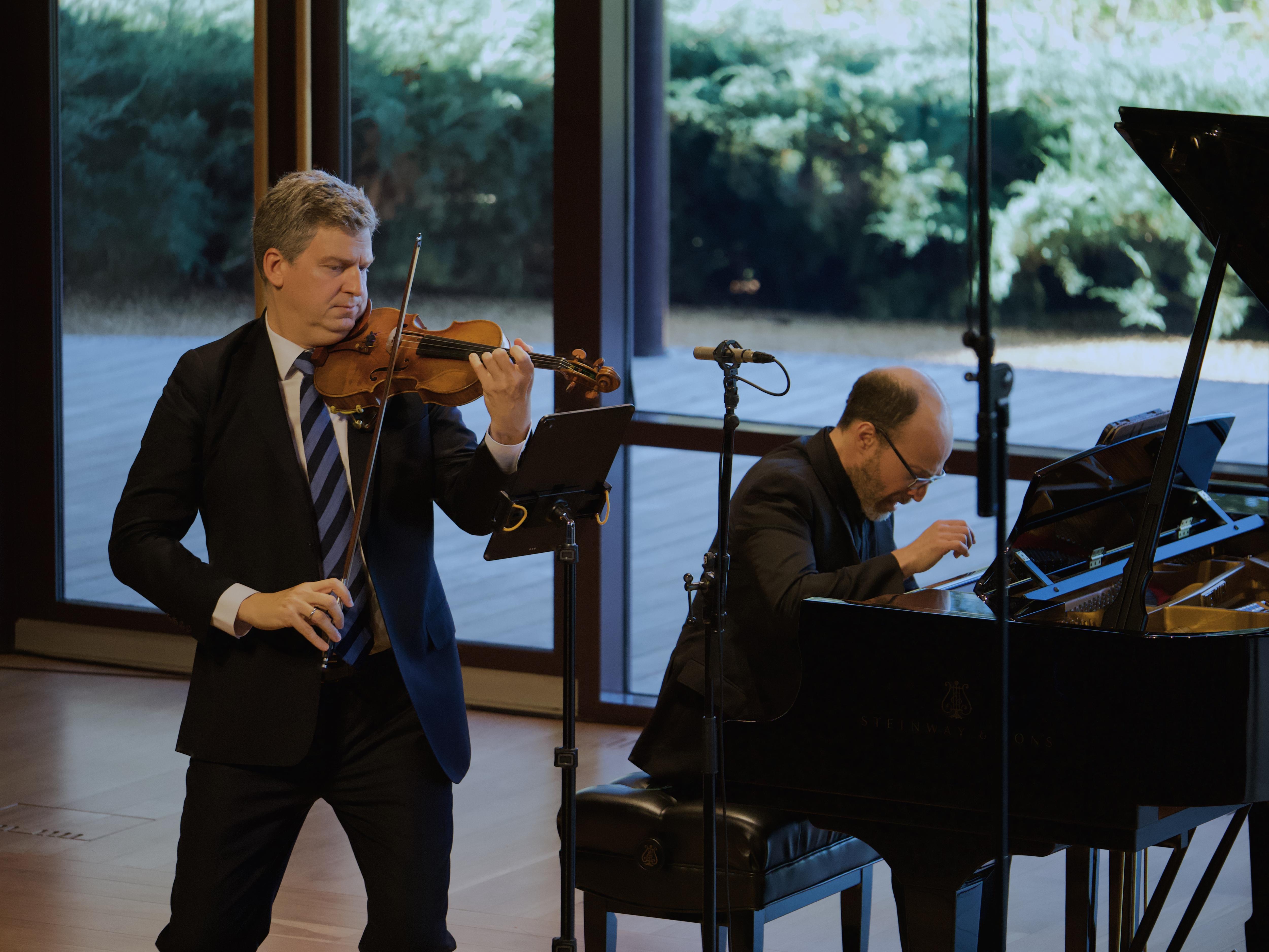 Violinist James Ehnes and pianist Orion Weiss performing at Ukaria, with a view of the gardens through the glass stage wall