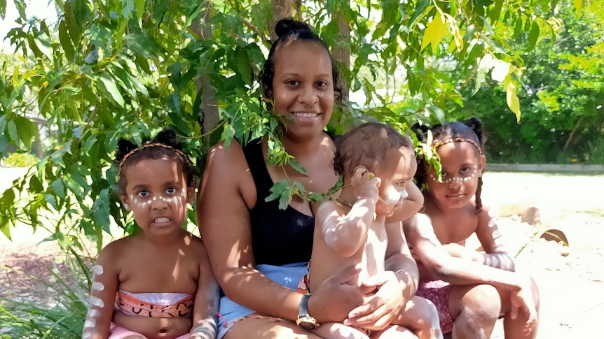 Mackapilly Sebasio with her three children under a tree. Supplied 2021