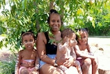 Mackapilly Sebasio with her three children under a tree. Supplied 2021
