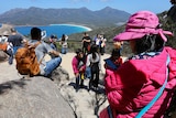 Tourists take photos from the Wineglass Bay lookout