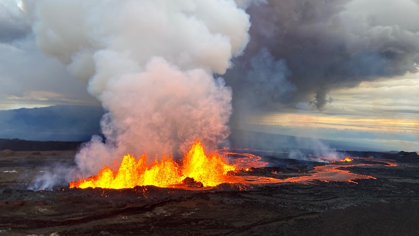 Lava erupts above dark lava fields, sending large plumes of smoke into the atmosphere