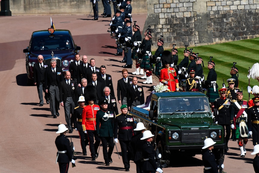 the british royal family and military personnel near a land rover hearse carrying prince philip during his funeral procession 