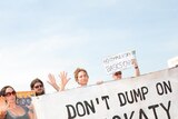 Protesters hold a 'Don't dump on Muckaty' sign outside Charles Darwin University