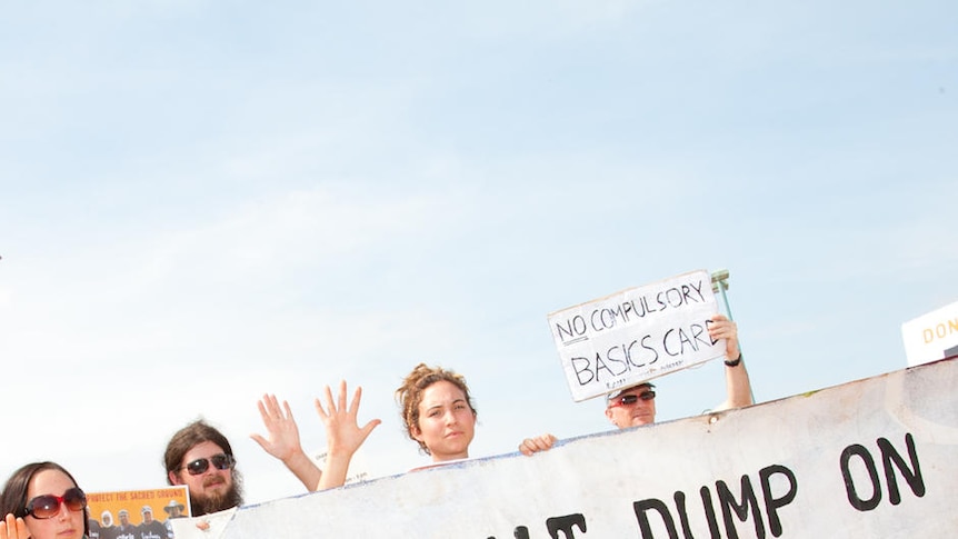 Protesters hold a 'Don't dump on Muckaty' sign outside Charles Darwin University