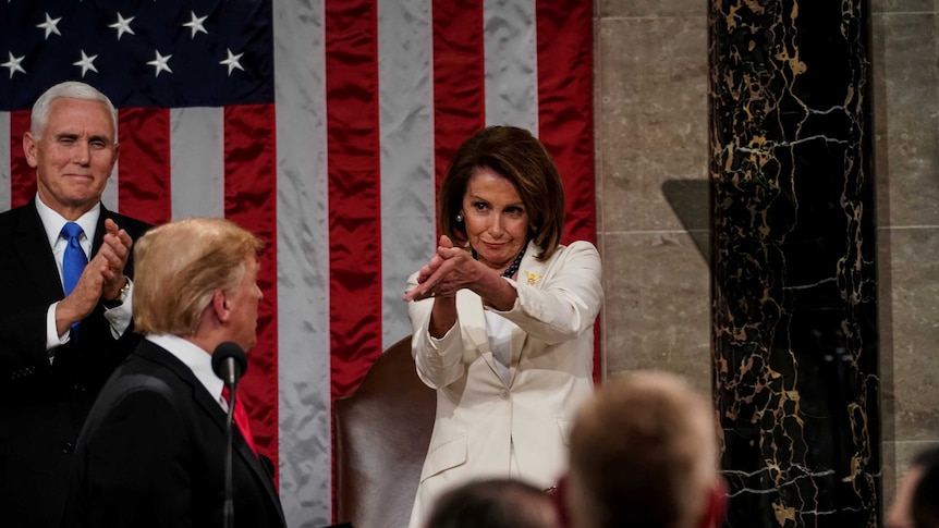 A photo of Nancy Pelosi clapping while Donald Trump looks perturbed