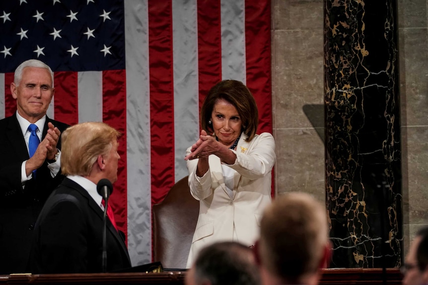 A photo of Nancy Pelosi clapping while Donald Trump looks perturbed