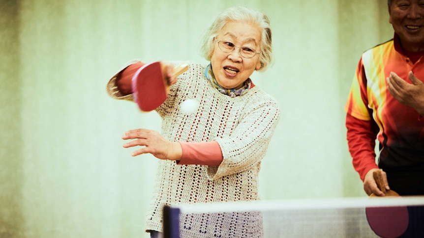 older woman playing table tennis