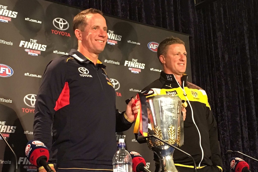 Don Pyke and Damien Hardwick smile while holding up the premiership cool.