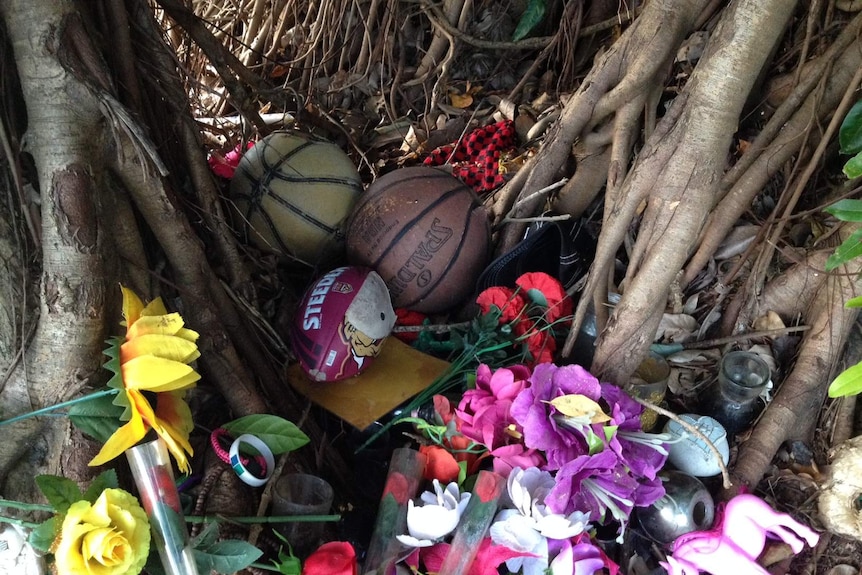 Tributes remain in a fig tree near the Manoora home.