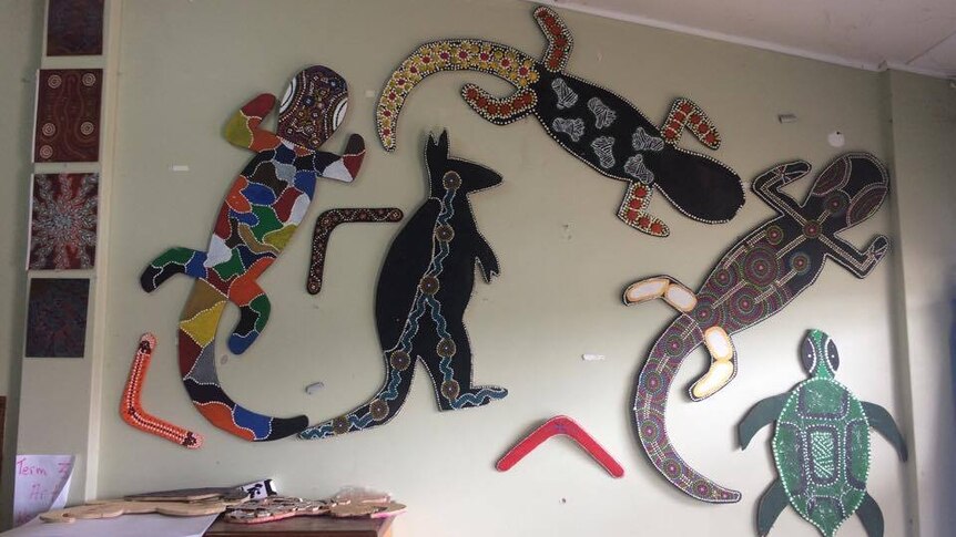 Large cardboard cut outs of Australian animals painted in different colours and dots hang on a wall