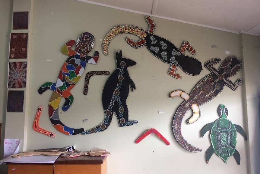 Large cardboard cut outs of Australian animals painted in different colours and dots hang on a wall