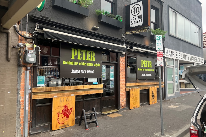 The exterior of a Japanese restaurant with a sign that reads 'Peter remind me of the upside again'.