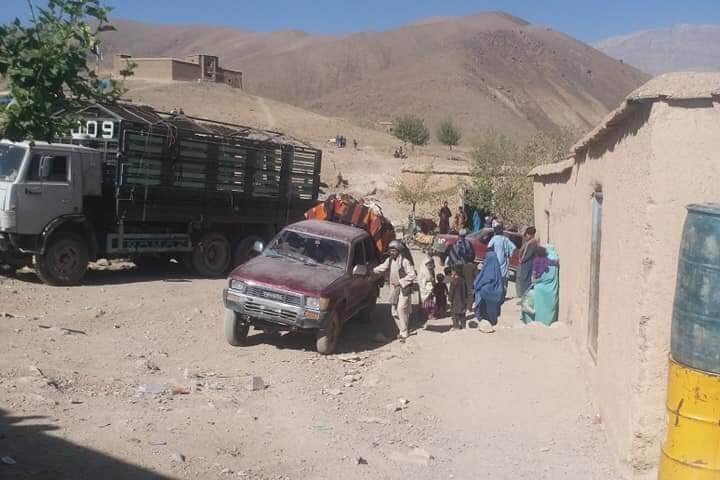 Families back their belonging into a pickup truck.