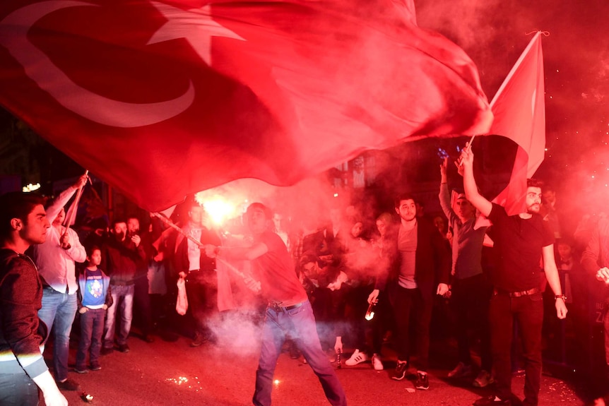 People wave flags on the street.