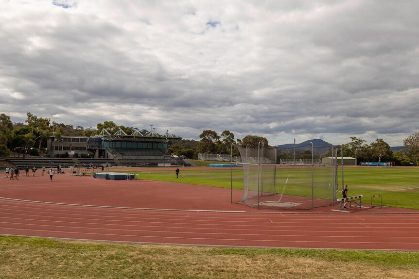 Athletics facility with a number of participants on the field.