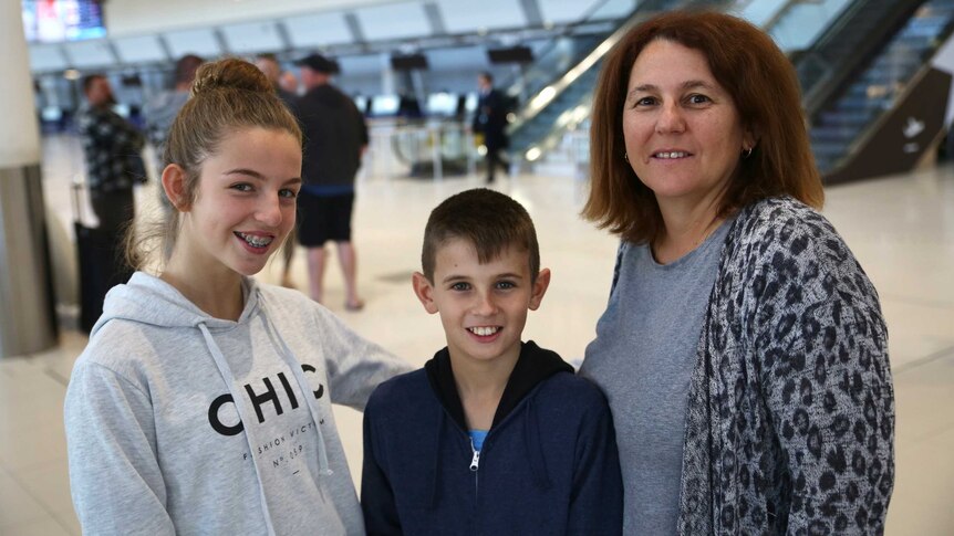 Erica Hunt with her two children Laura and Josh stand at Perth Airport.