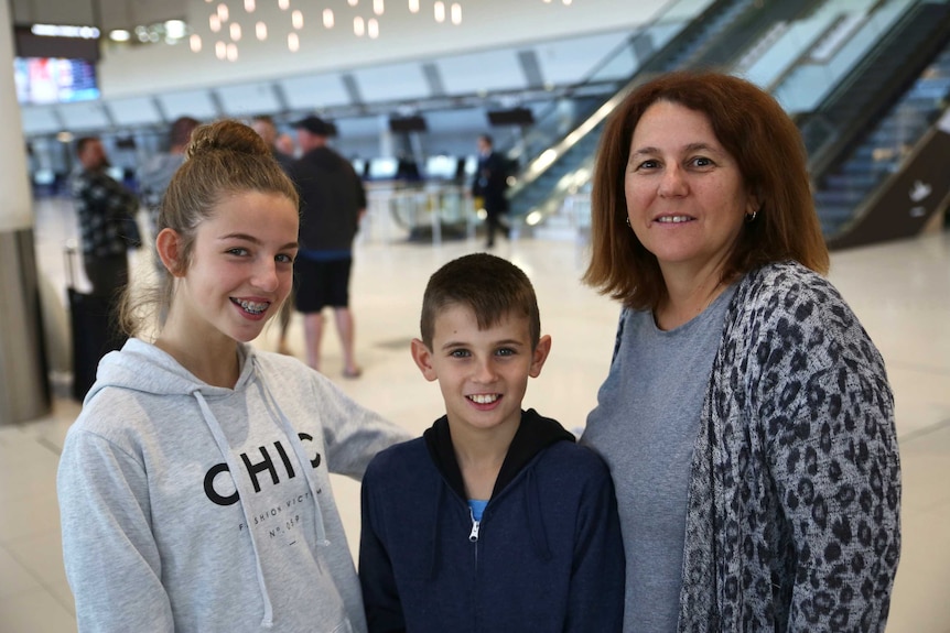 Erica Hunt with her two children Laura and Josh stand at Perth Airport.