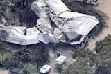 The crumpled silver roof of a house destroyed by fire