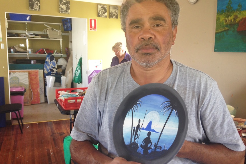 Cherbourg artist Rocko Langton, one of the original Barambah Potters, with one of his pieces