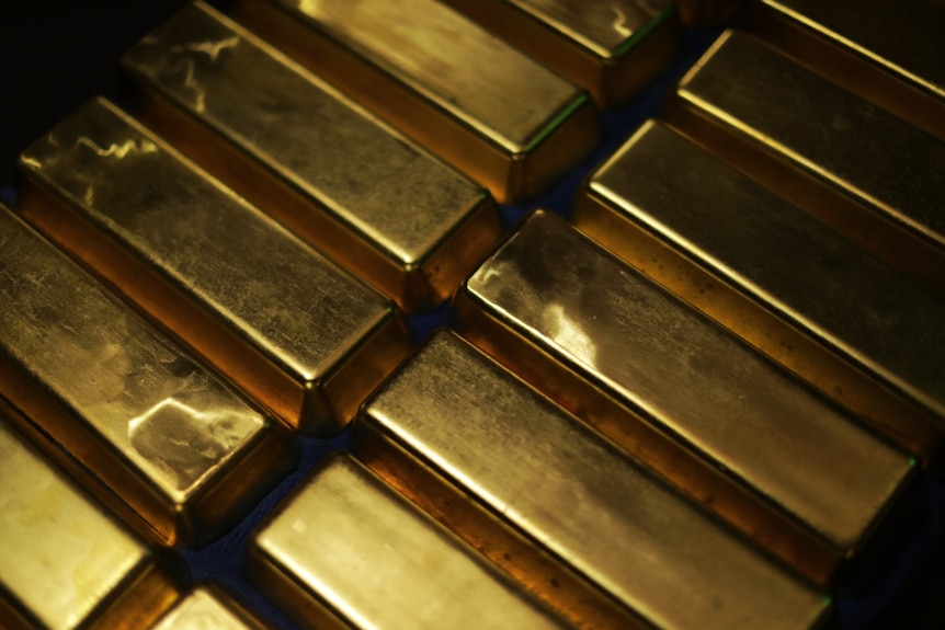Two rows of gold bars lined up. Their surfaces shine.