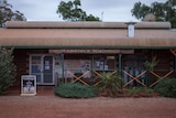 A roadhouse surrounded by trees, with a sign that says 'Tjukayirla Roadhouse'