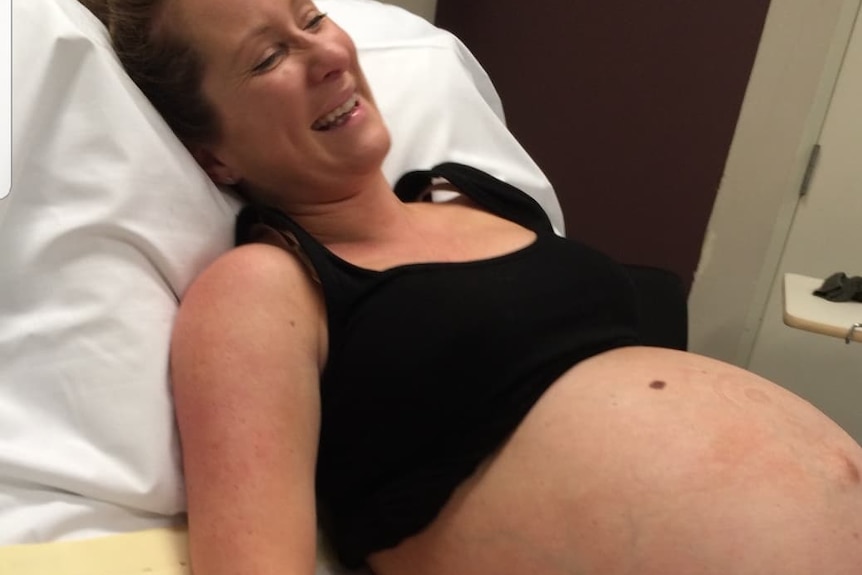 Exposed pregnant belly of woman in hospital bed not long before birthing