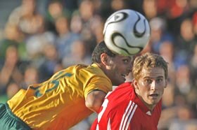 Australian forward John Aloisi attempts to head the ball past a Liechtenstein defender.