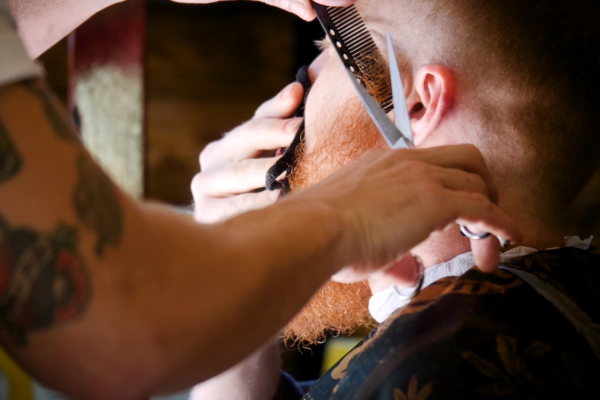 The scissors trim Brent's red beard.