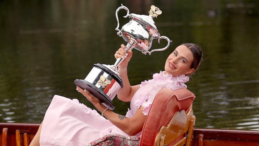A woman in a boat holding a trophy