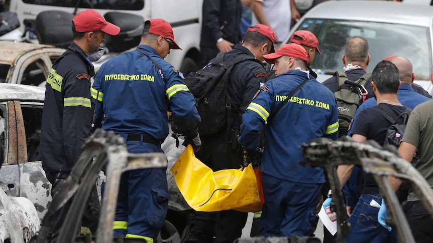 Crews remove body from burned cars in Mati, Greece