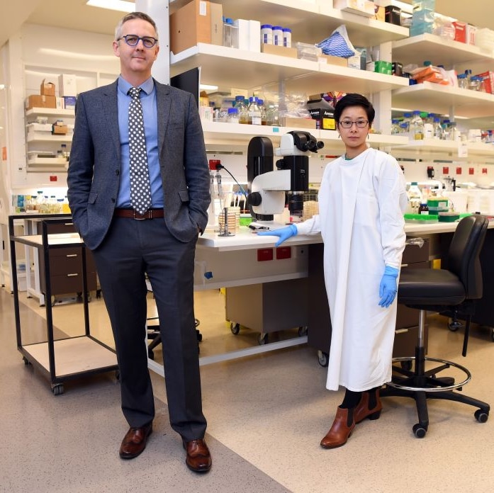 Ben Howden and colleague Jean Lee pictured standing in a large laboratory