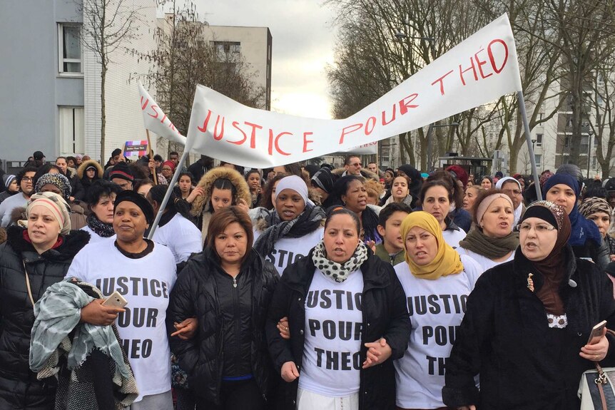 Protesters carrying a "Justice for Theo" banner march in the streets of Aulnay-sous-Bois.