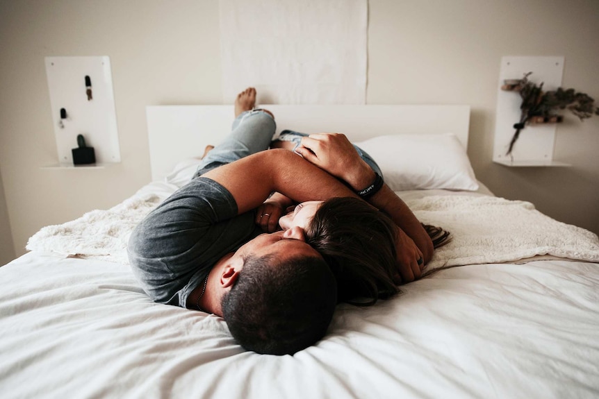 A couple embracing on a bed to depict antidepressants affecting sex drive and what to do.