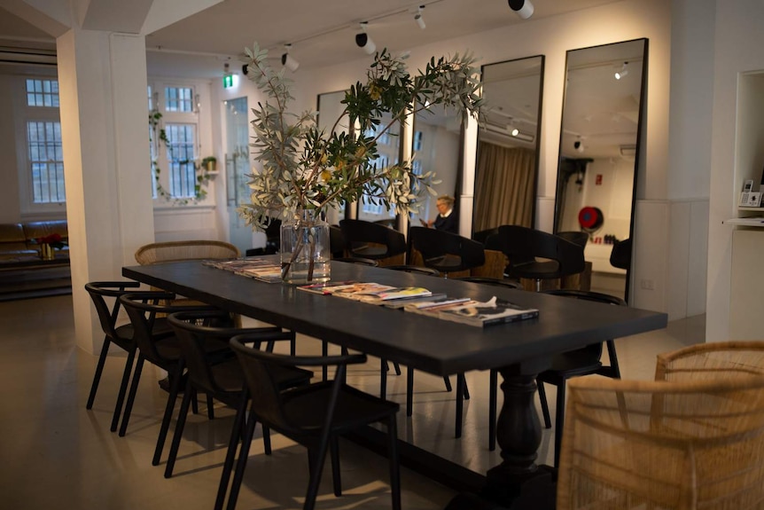 A large table, with several empty chairs around it.