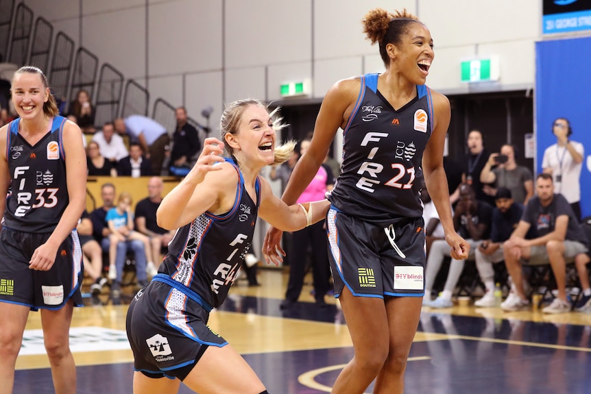 Karlie Samuelson and Tianna Hawkins shout and smile after winning the WNBL Finals for the Townsville Fire.