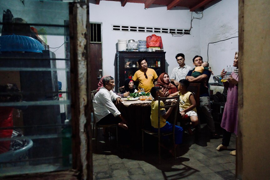 An Indonesian family sitting together in a kitchen