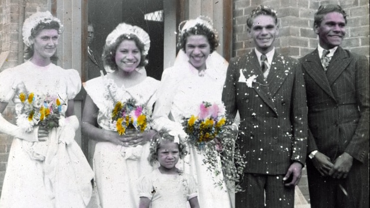 Three brides, two groomsmen and a flower girl smiling outside a church in the 1950s.
