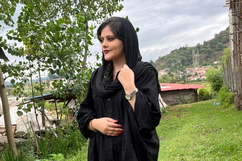 Imágenes de una mujer joven con un hiyab negro suelto y mirando a la cámara