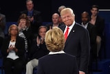 Donald Trump looks at Hilary Clinton with a smile before the debate